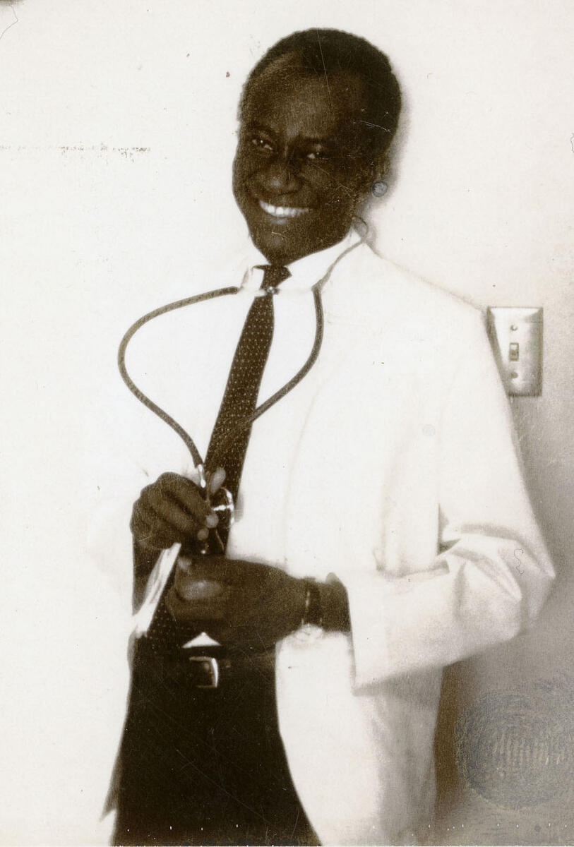 Candid of Akwari in a white coat with his stethoscope