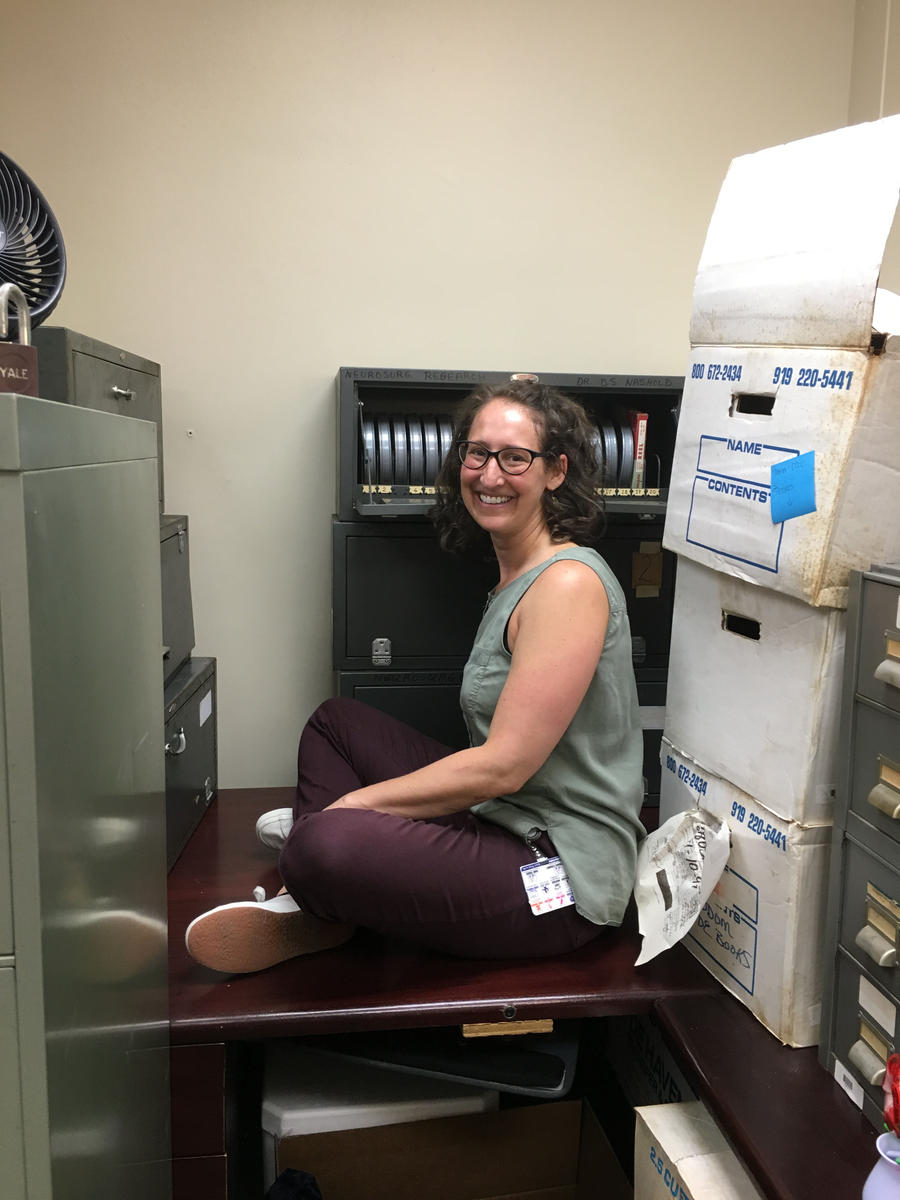 Technical Services Head Lucy Waldrop making use of a flat surface while packing up the Department of Neurosurgery materials.